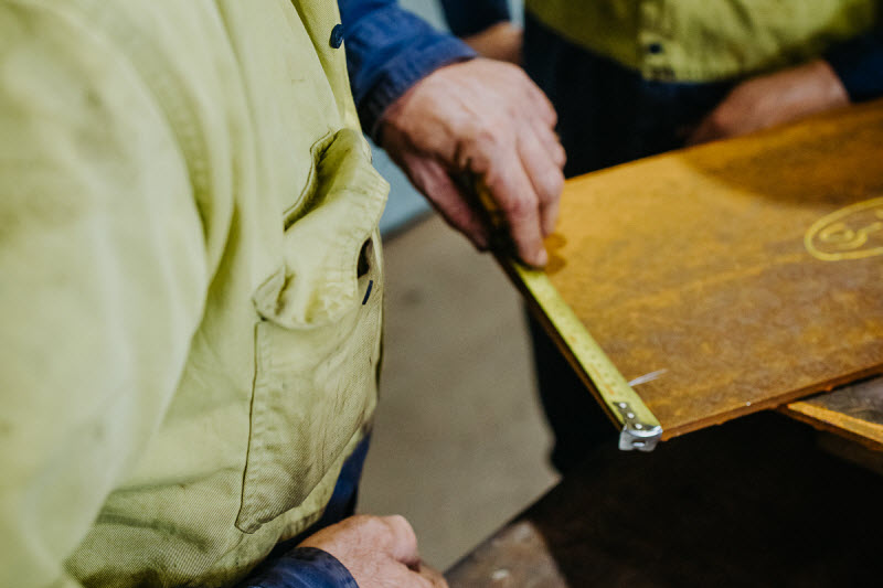 Men measuring a steel sheet